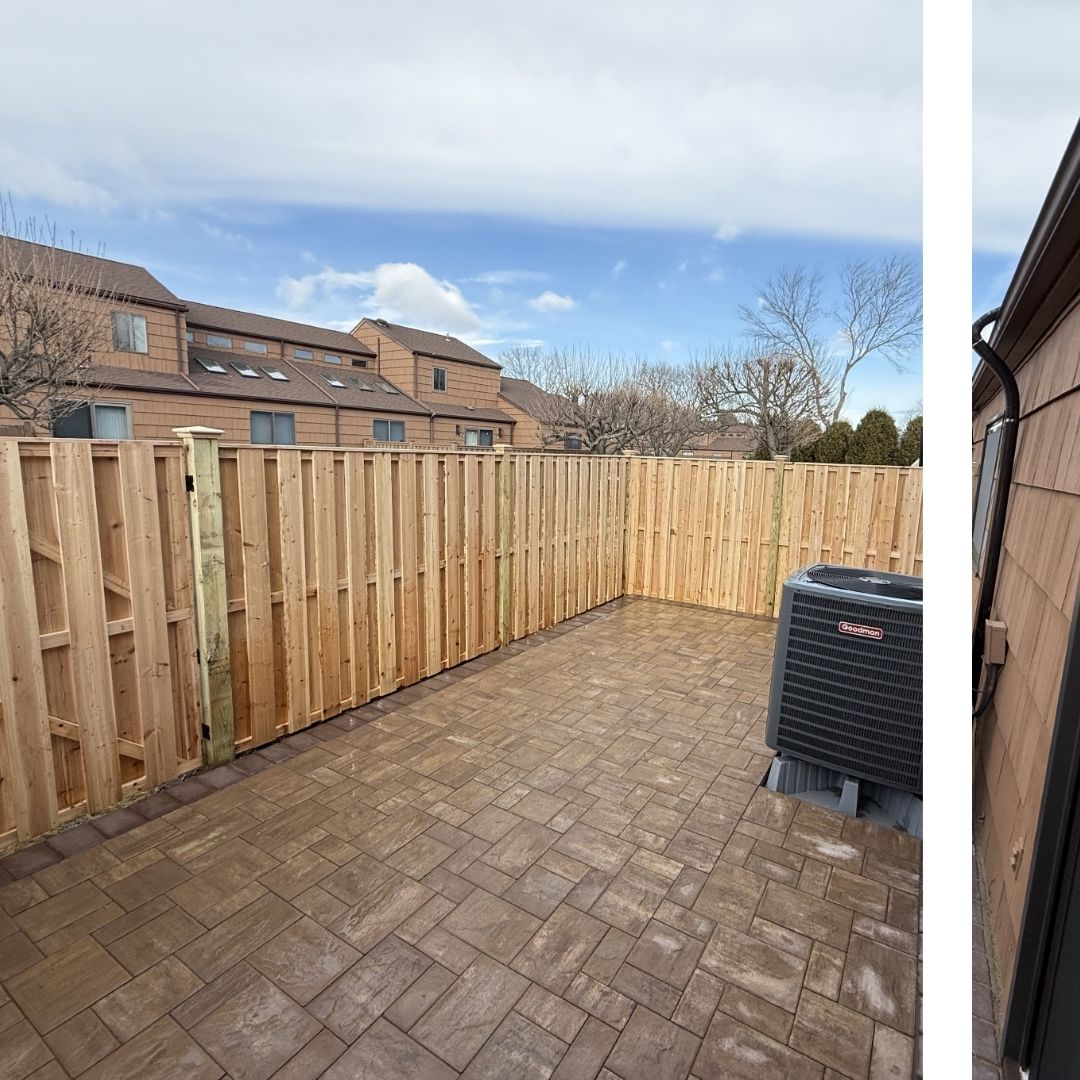 New pressure-treated wood privacy fence enclosing a paved backyard patio