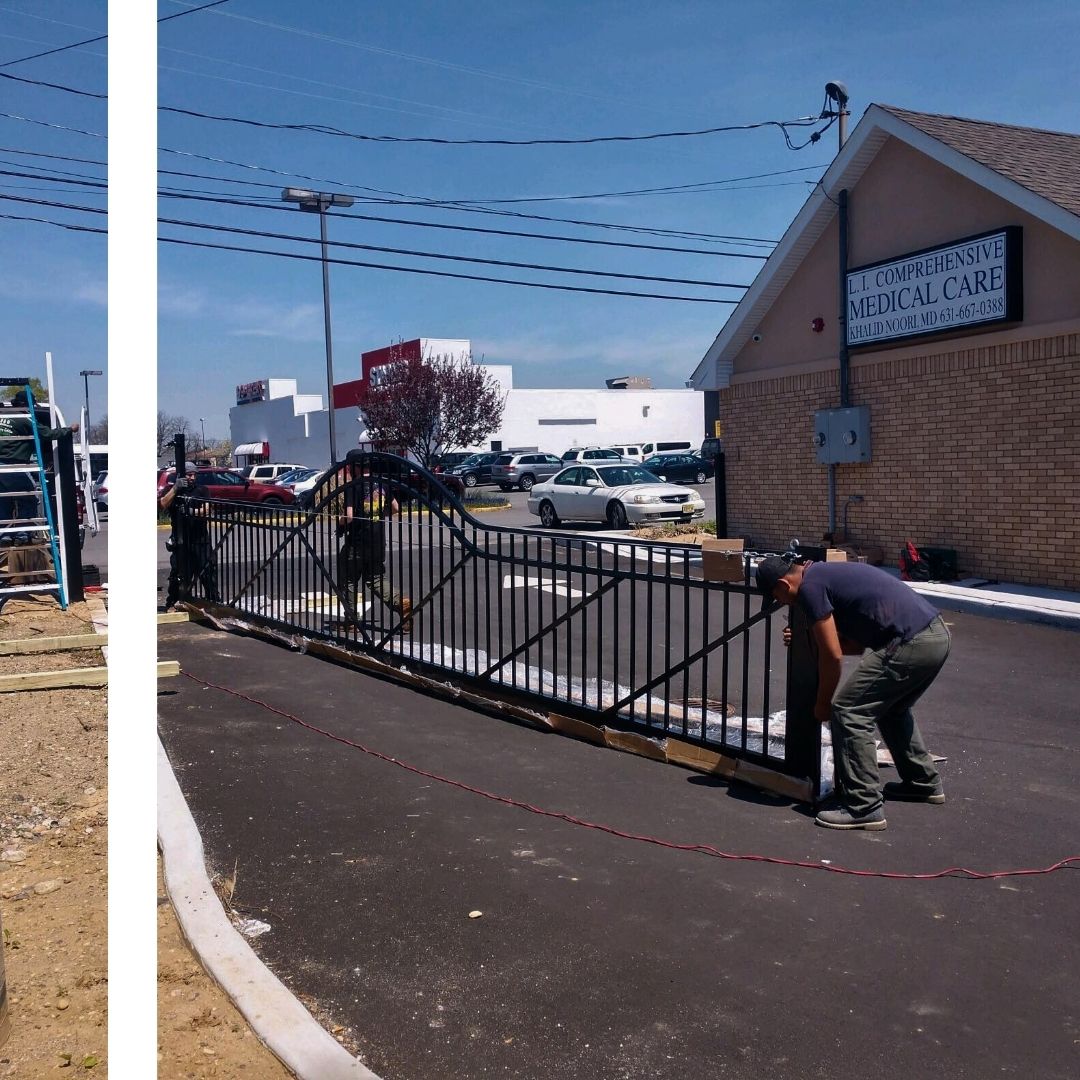 Three workers in a paved lot are installing a large, black ornate metal gate, with a building labeled "L.I. Comprehensive Medical Care" visible in the background on the right.