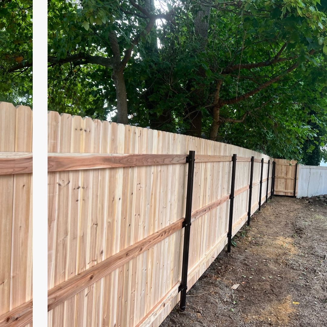 natural wood privacy fence with sturdy black posts, showing the structural integrity of the installation